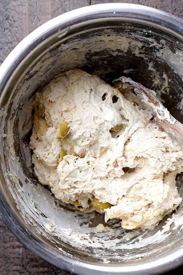 Close-up overhead shot of bread dough with mixed-in olives.