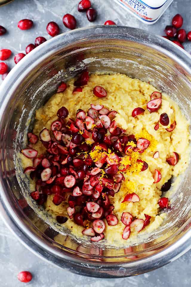 A bowl with batter and cranberries prepared to make Cornbread Muffins.