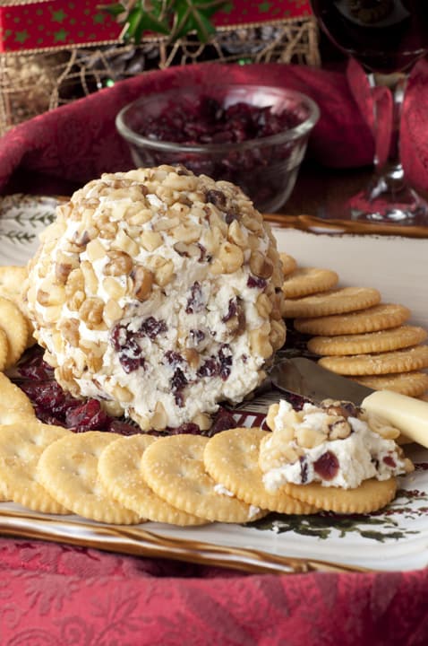 Cranberry Walnut Cheese Ball surrounded by crackers on a serving tray