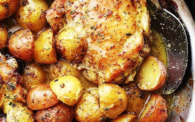 Chicken thighs and Potatoes in a pan.
