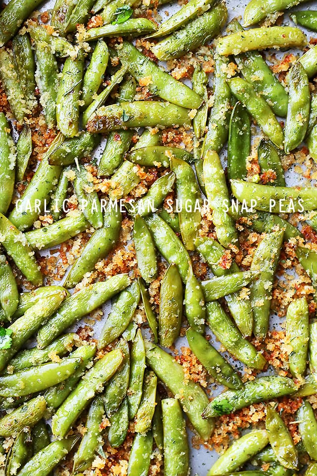 Garlic Parmesan crumb-coated Sugar Snap Peas spread out on a light backdrop.