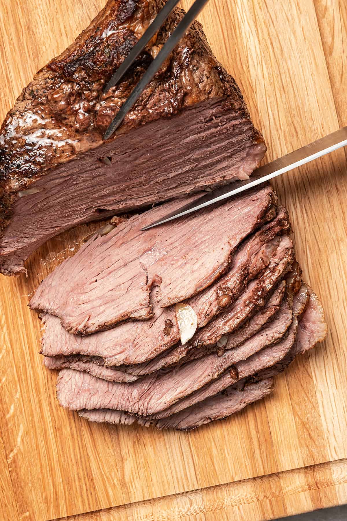 Slicing roast beef on a cutting board.