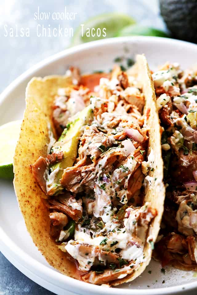 Close-up shot of a taco filled with shredded chicken and topped with avocado slices.