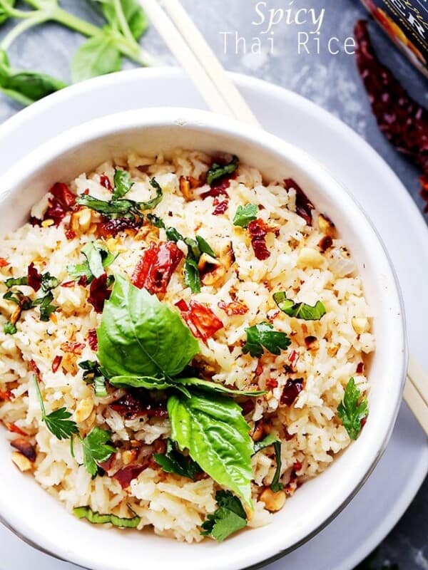 Overhead view of a bowl of Thai fried rice garnished with basil leaves.