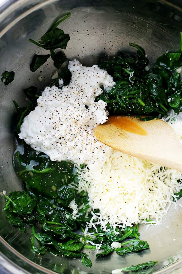 Mixing baby spinach and cheeses.