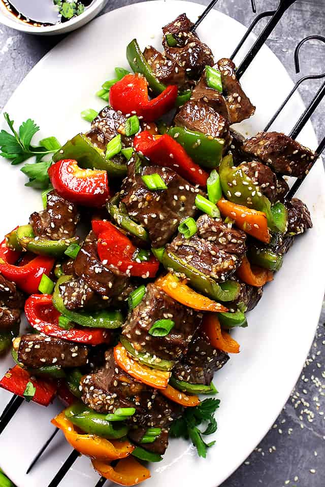 Skewered beef and vegetables served on a white plate.