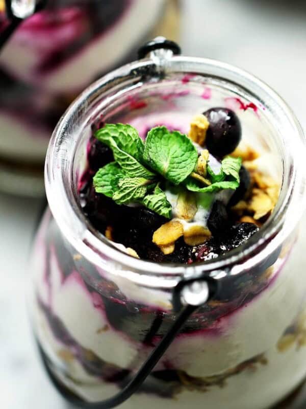 No Bake Skinny Blueberry Cheesecake Parfaits - Delicious layers of lightened-up creamy and lemony cheesecake filling, sweet granola, and a homemade blueberry sauce.