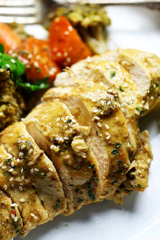 Garlic lime chicken breast sliced next to vegetables on a plate.