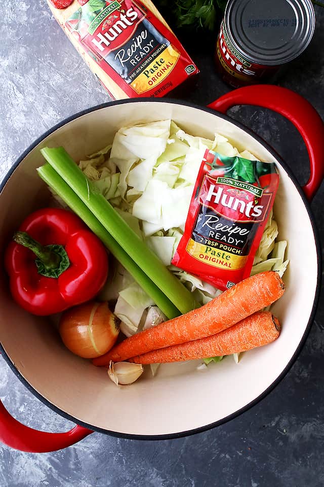 Ingredients for cabbage soup with rice in a soup pot.