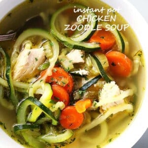 Close up shot of a bowl of soup made with zucchini noodles, carrots, and chicken.