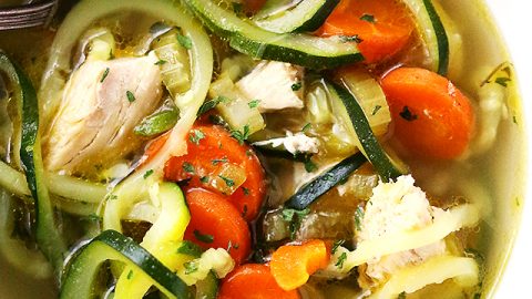 Close up shot of a bowl of soup made with zucchini noodles, carrots, and chicken.
