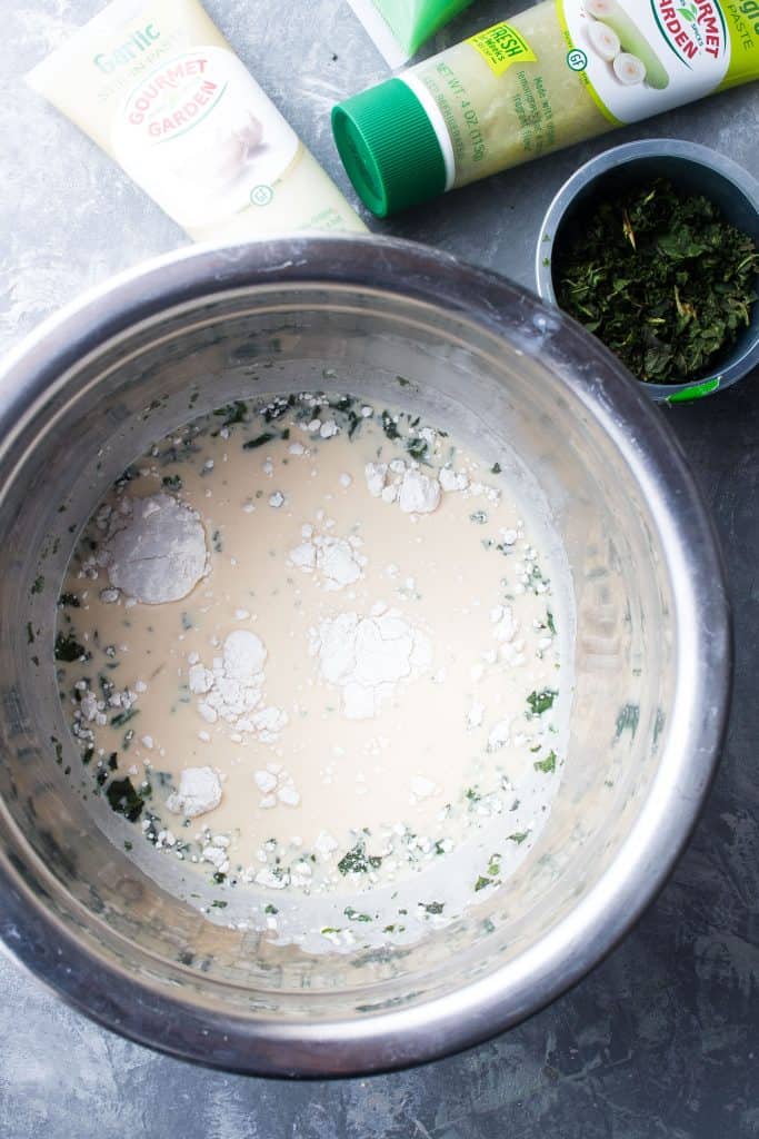 The garlic cream sauce ingredients combined in a metal mixing bowl.
