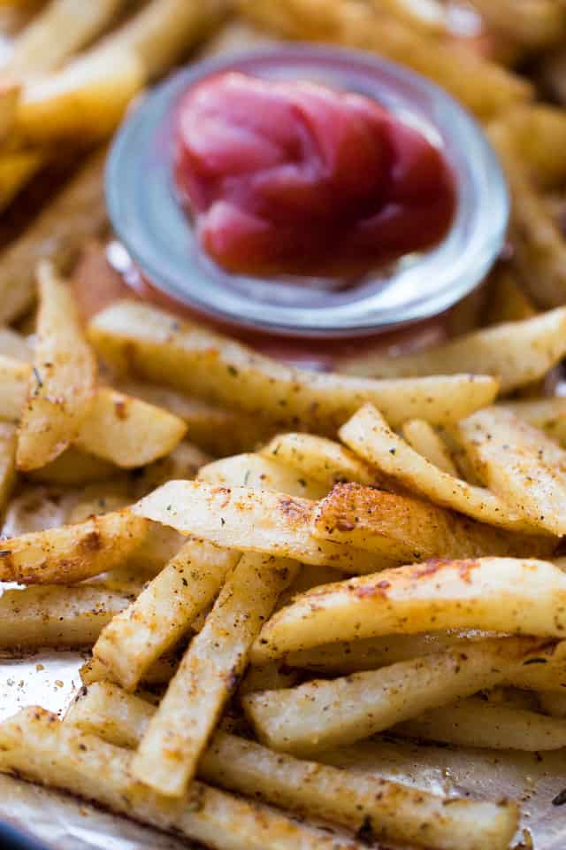 Oven Baked Seasoned French Fries served with a small bowl of ketchup.