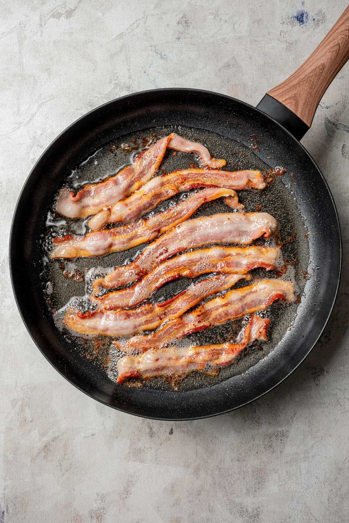 Bacon cooking in a skillet.