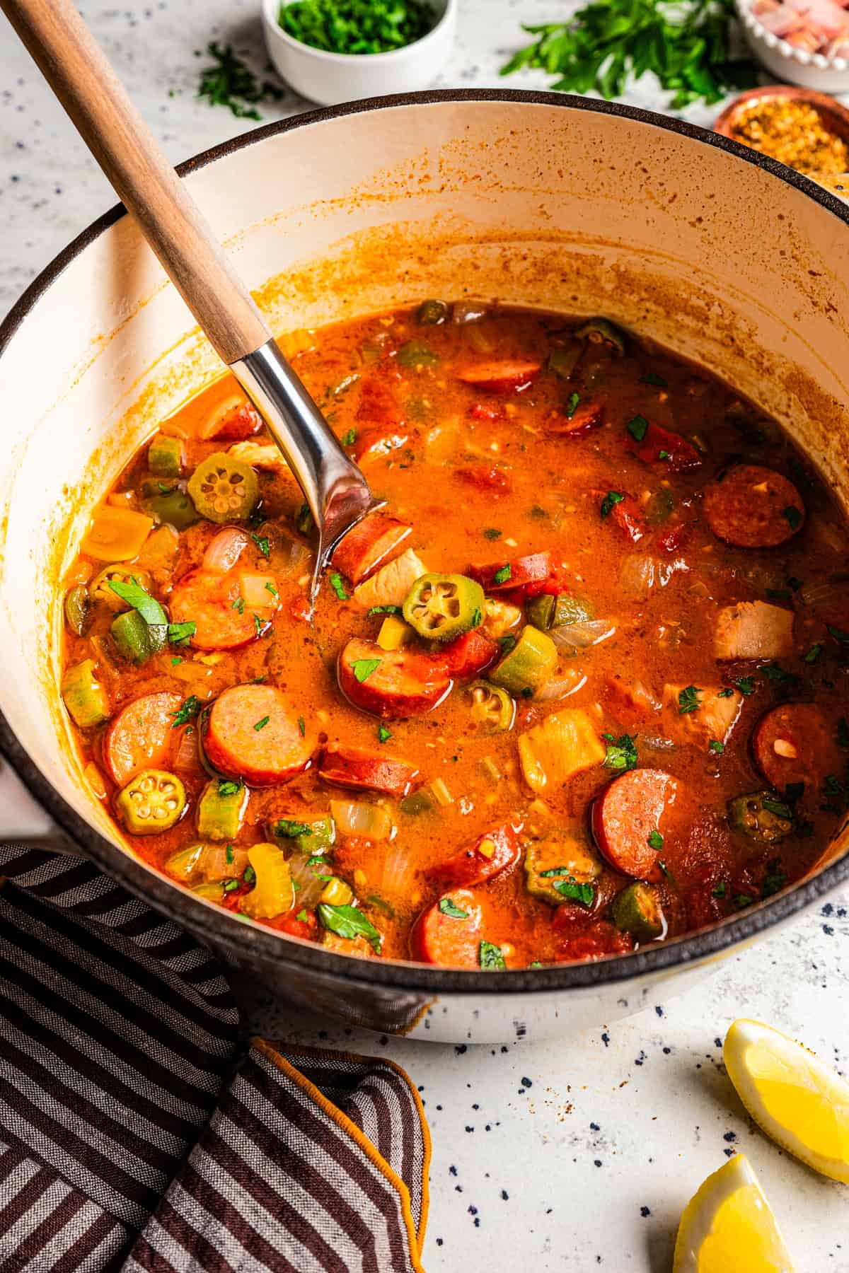 A ladle resting in a pot of gumbo.