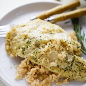 One Pan Risotto with Garlic Herb Tilapia - Delicious, garlicky Tilapia set over a flavorful bed of rice and baked to a creamy perfection!