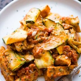 Chicken and zucchini noodles tossed in vodka sauce and served on a plate.