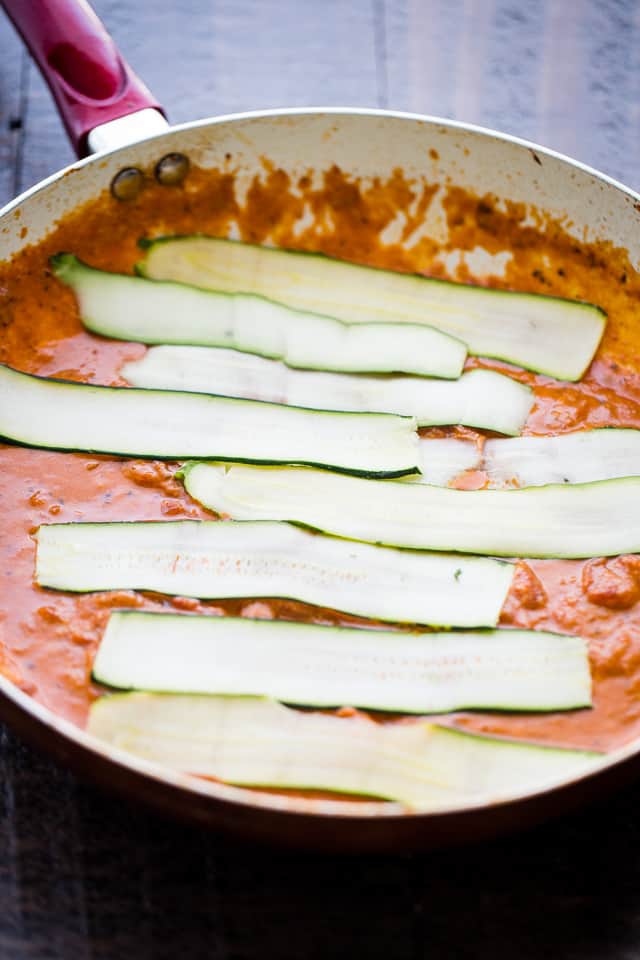 Zucchini Noodles laying on top of vodka tomato sauce in a skillet