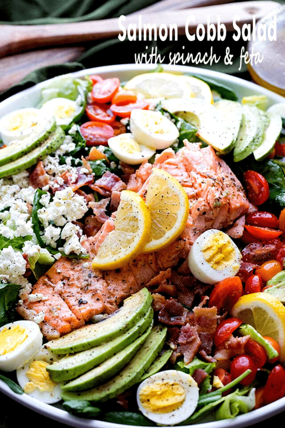 Salmon Cobb Salad with Spinach and Feta - Tender spinach and romaine lettuce topped with delicious oven-baked salmon, tomatoes, eggs, bacon, avocados and feta, all tossed together with a tangy lemon-mustard dressing.