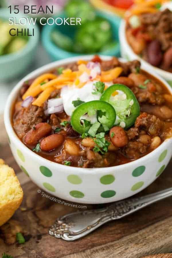 A bowl of 15 Bean Slow Cooker Chili topped with jalapeno slices, sour cream and shredded cheese