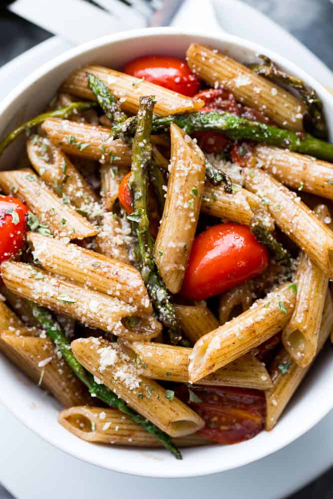 Penne pasta mixed with tomatoes and asparagus.