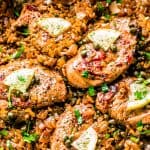 Chicken Piccata and Rice in the pan with parsley and lemon slices