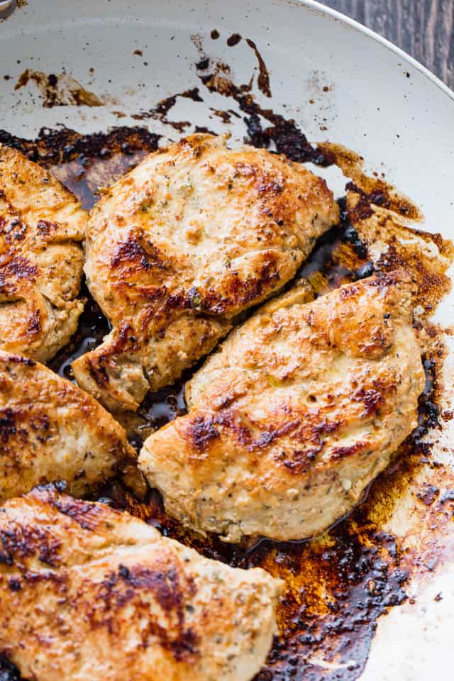 Lightly browned chicken breasts in the pan after being grilled in olive oil