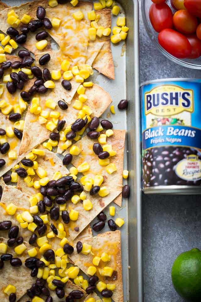 Sheet Pan Lime Chicken Nachos - Easy to make, fun, delicious nachos baked on a sheet pan and loaded with beans, corn, lime chicken, and cheese! Perfect for entertaining a crowd!