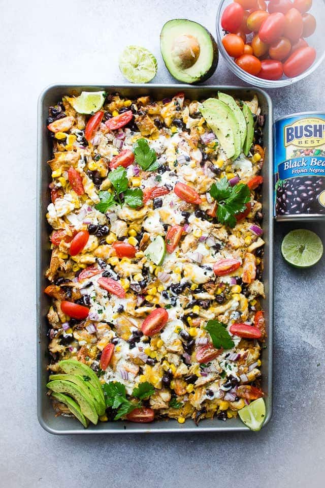 Sheet Pan Lime Chicken Nachos - Easy to make, fun, delicious nachos baked on a sheet pan and loaded with beans, corn, lime chicken, and cheese! Perfect for entertaining a crowd!