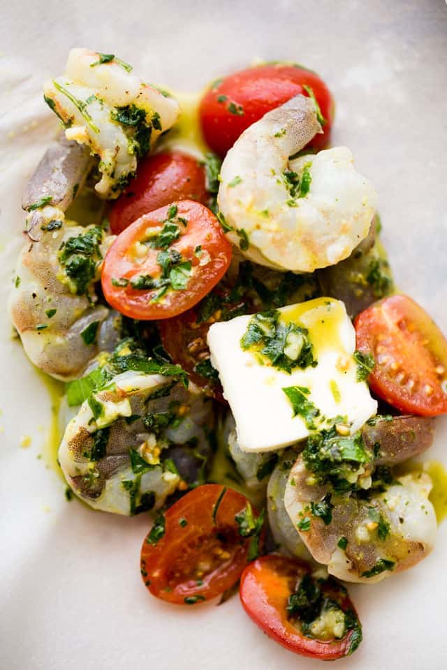 Shrimp and cherry tomatoes in a marinade with garlic, lemon juice, and herbs.