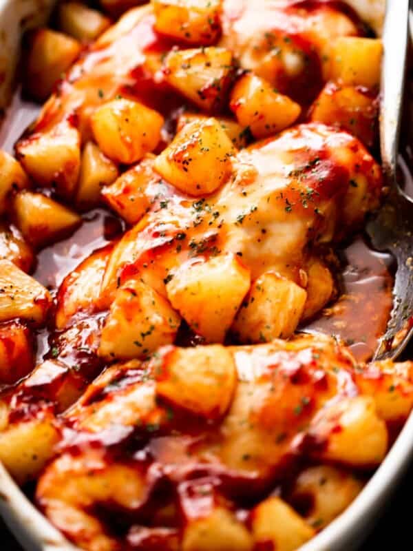 overhead shot of three chicken breasts topped with chunks of pineapple and smothered with barbecue sauce.