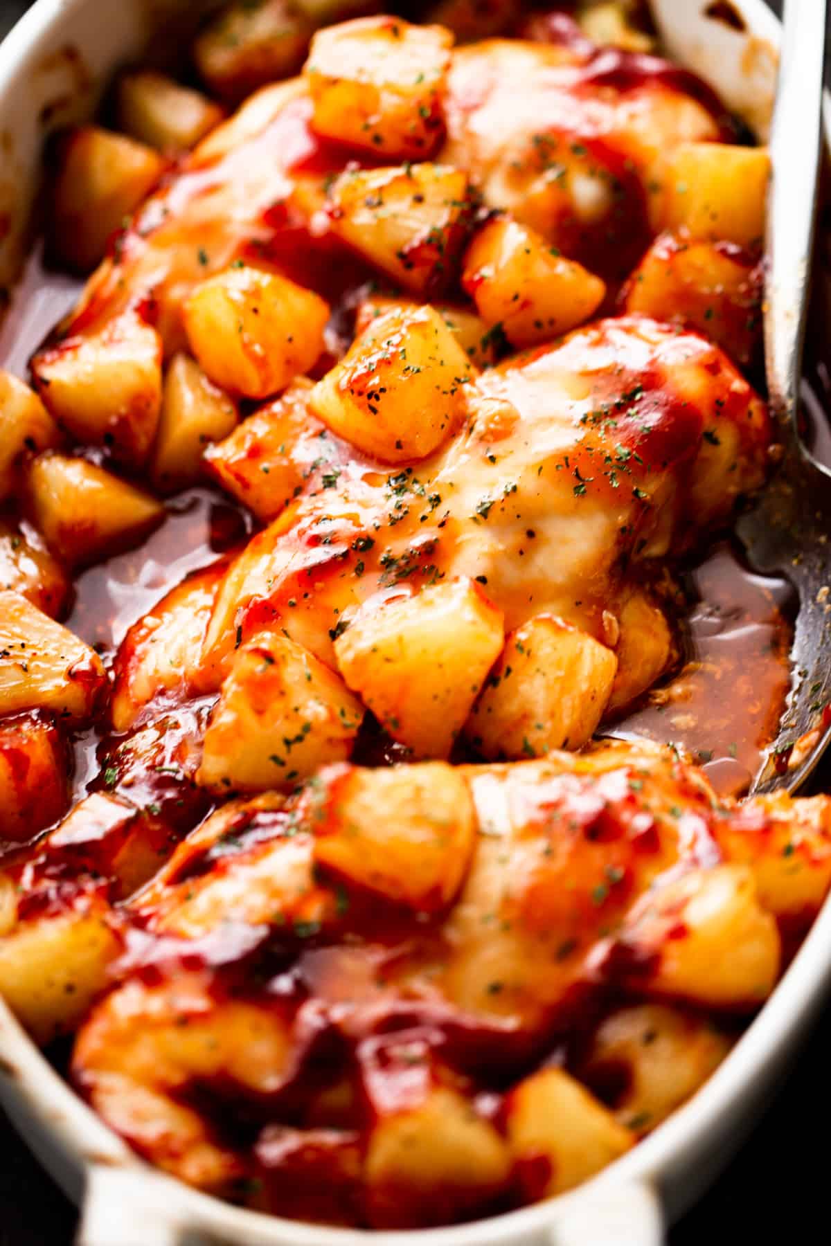 overhead shot of three chicken breasts topped with chunks of pineapple and smothered with barbecue sauce.