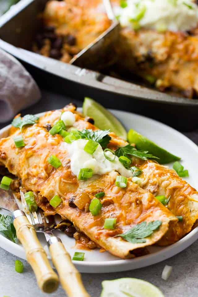 Two Enchiladas served on a dinner plate.
