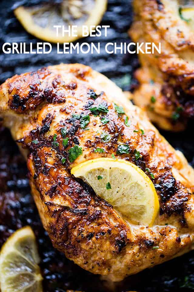 Up close photo of grilled chicken breast with grill marks and a slice of lemon placed on top of it.