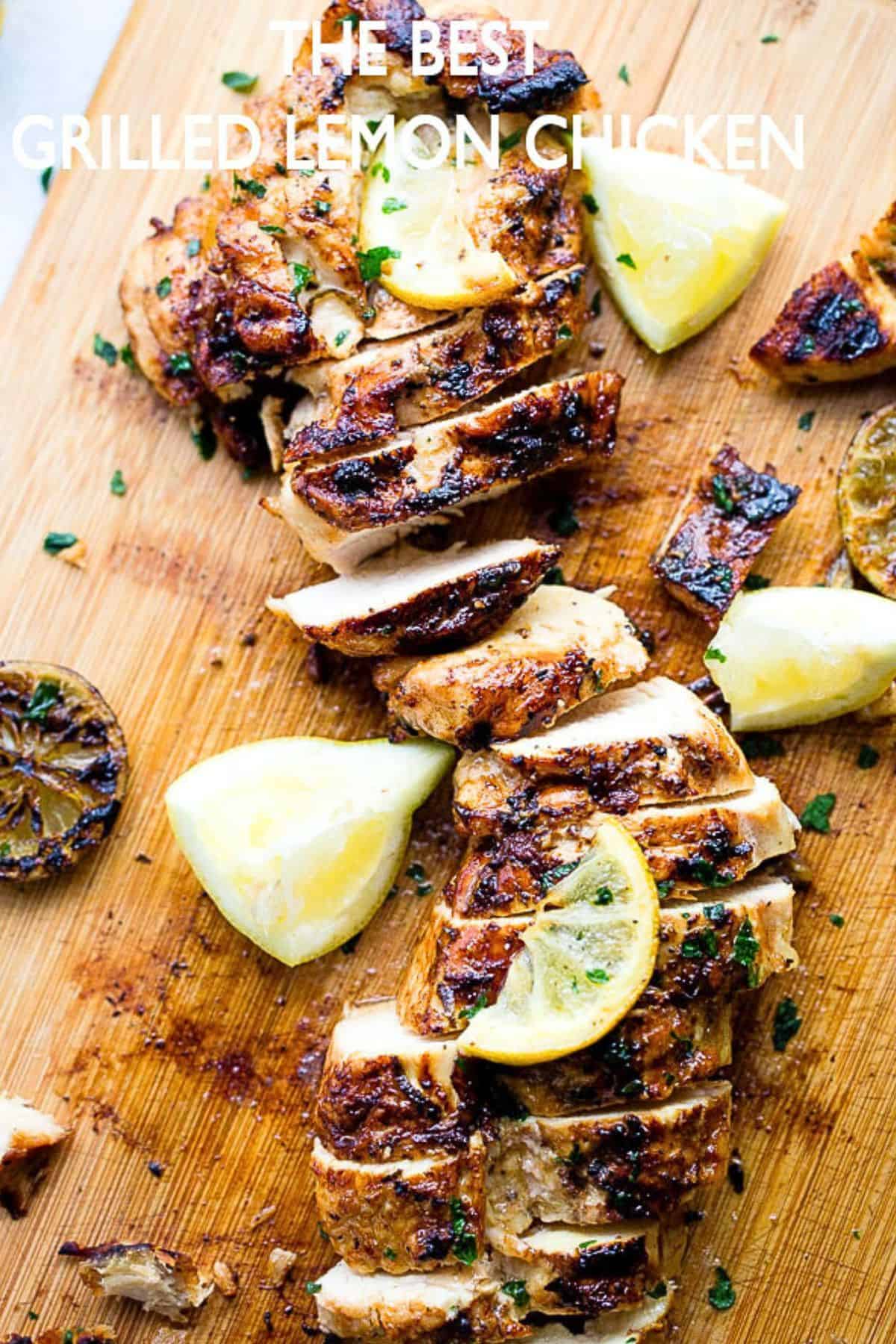 Sliced chicken breast on a cutting board with lemon slices arranged around it.