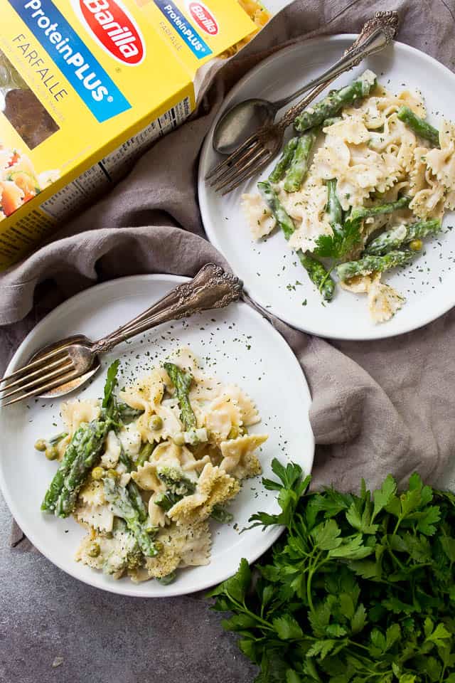 Plates of asparagus pasta with peas and cream sauce.