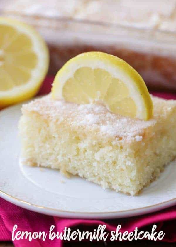 A square of frosted lemon buttermilk sheet cake with a lemon slice garnish on a plate