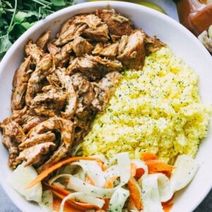 Pulled Tandoori Chicken Rice Bowls - Deliciously juicy chicken breasts cooked in tandoori marinade and served over flavorful lemon rice and a cucumber salad.