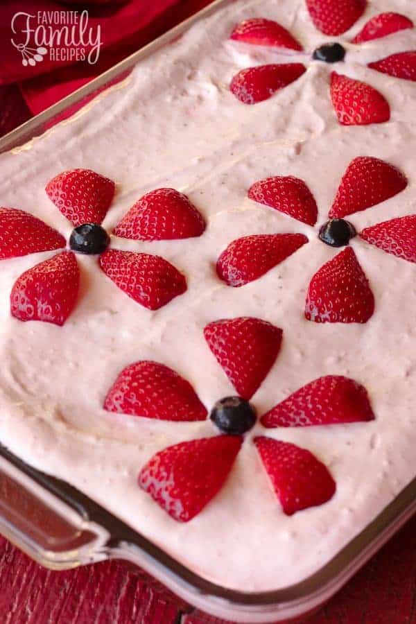 Strawberries and Cream Cake in a 9x13 pan with flower-shaped strawberries on top