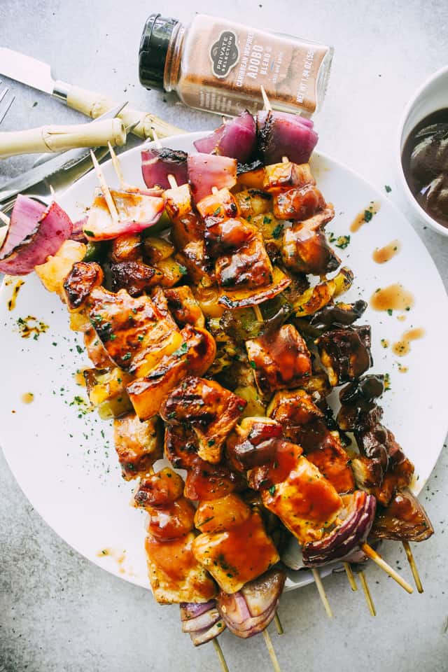 Perfectly seared Pineapple BBQ Pork Kebabs smothered in homemade barbecue sauce and stacked on a plate.