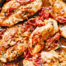 Top view of chicken breasts with Creamy Sun Dried Tomato Sauce in a skillet