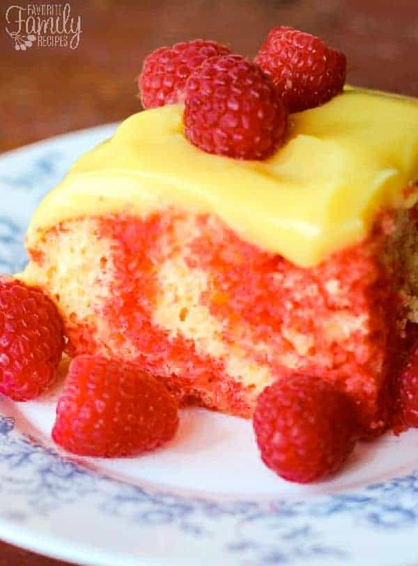 A square of marbled Raspberry Lemon cake with lemon frosting and fresh raspberries