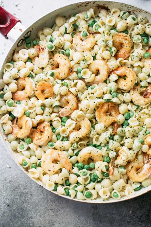 Overhead view of White Cheddar Shells and Cheese with Shrimp and Peas in a skillet