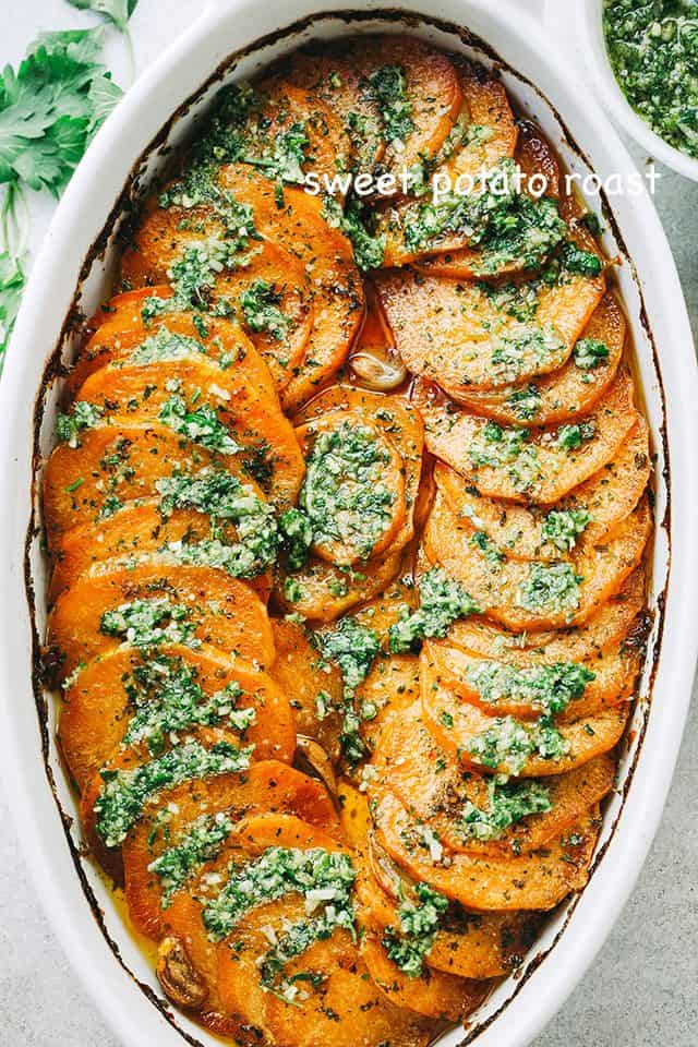 Overhead view of Sweet Potato Roast with Parsley Pesto in an oval casserole dish