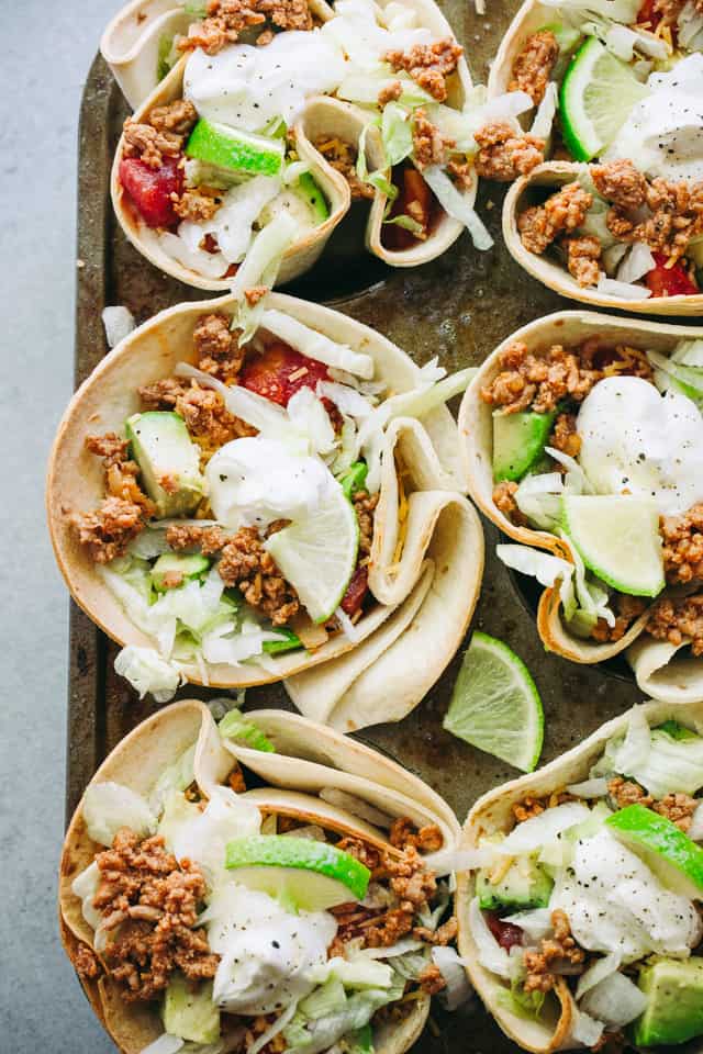 Overhead view of Taco Bowls filled with taco-seasoned ground turkey meat, salad, tomatoes, cheese, and topped with a dollop of sour cream