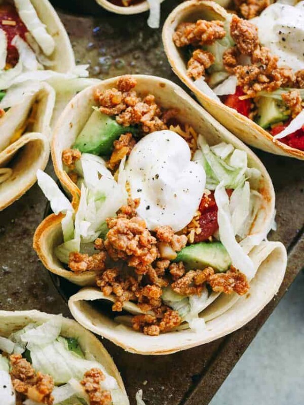 Taco Bowls - Fun and delicious baked flour tortilla bowls filled with taco-seasoned ground turkey meat, salad, tomatoes, cheese, and topped with a dollop of sour cream!