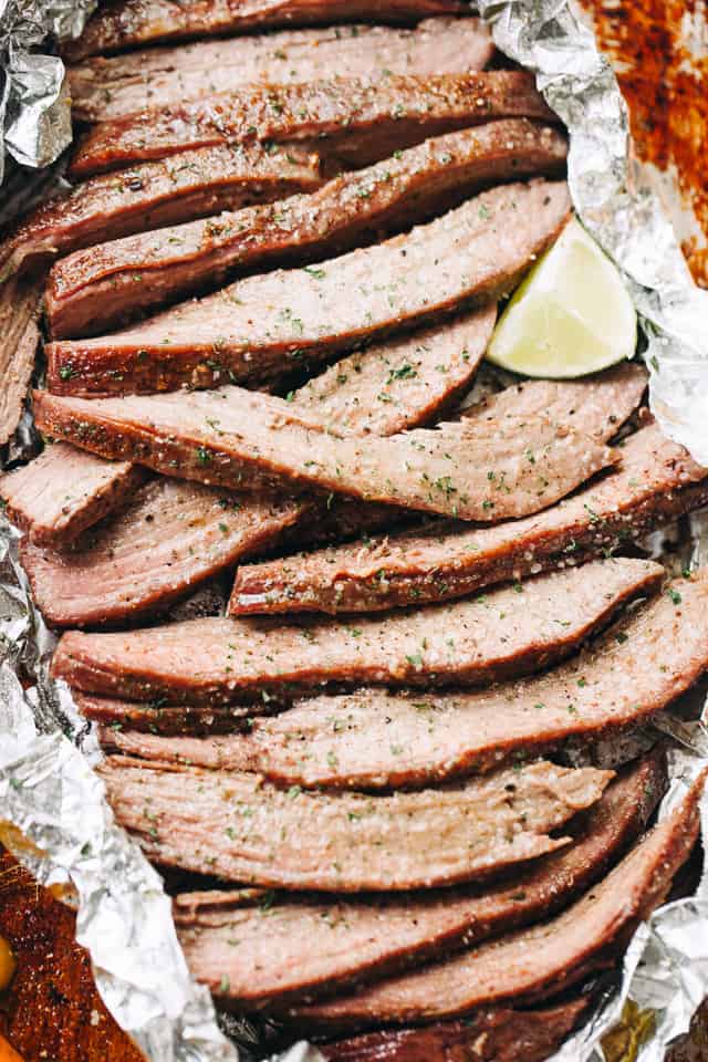 Sliced flank steak with a lime wedge.