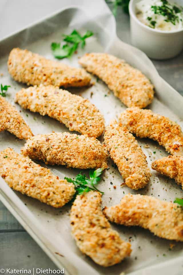 Baked Chicken Tenders with Chili Yogurt Sauce - Juicy, crispy, delicious chicken tenders coated with a flavorful parmesan panko mixture and served with a zingy chili yogurt sauce.
