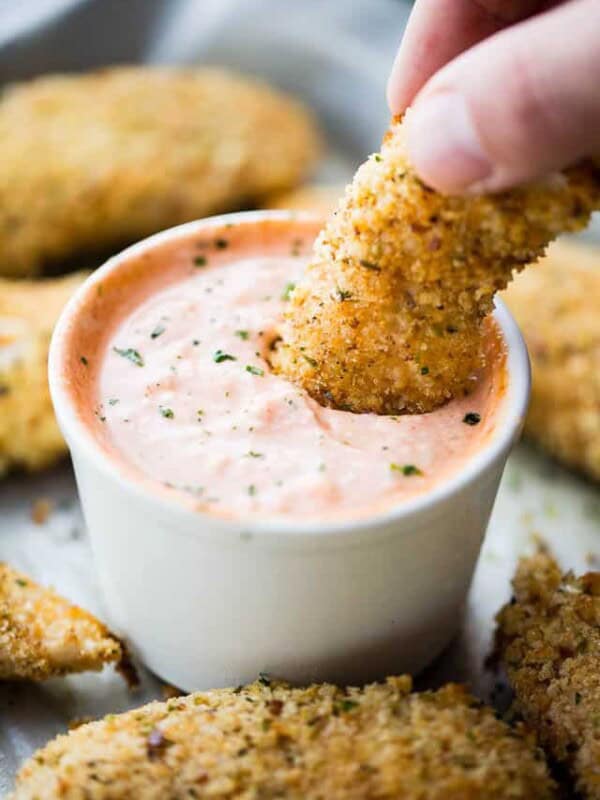 Baked Chicken Tenders with Chili Yogurt Sauce - Juicy, crispy, delicious chicken tenders coated with a flavorful parmesan panko mixture and served with a zingy chili yogurt sauce.