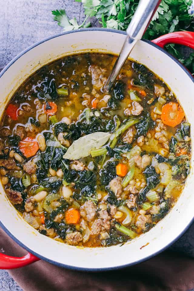 Italian Sausage Soup with Kale and Beans in a dutch oven.